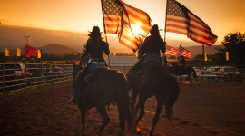 People on horses holding American flags.
