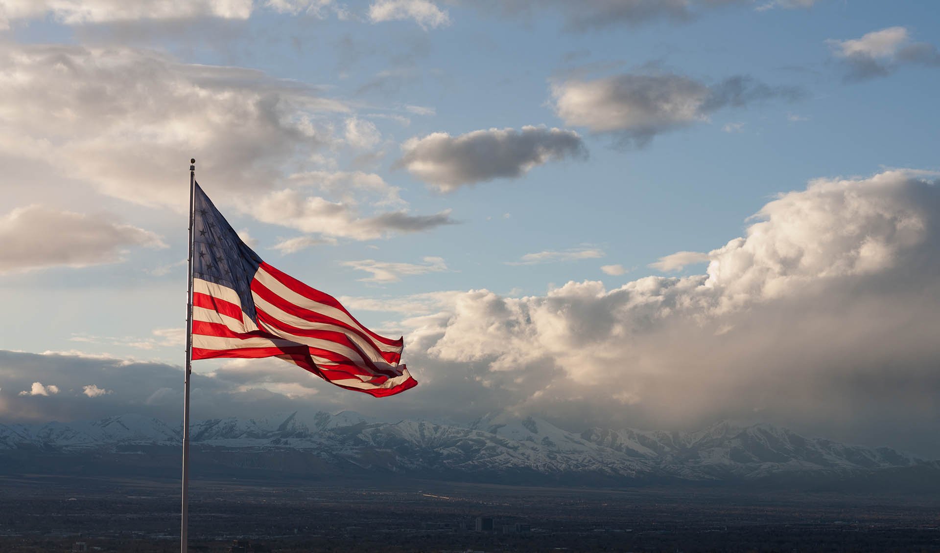 American Flag flying over a mountain range